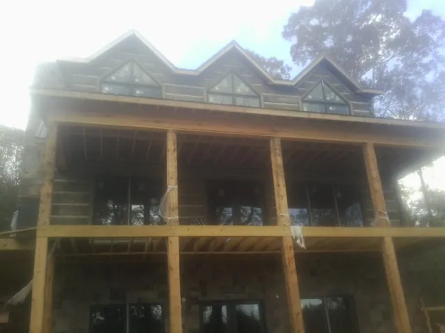 Dormers and porch framing on a large log home under construction — Roof Coating work by our crew in Amston