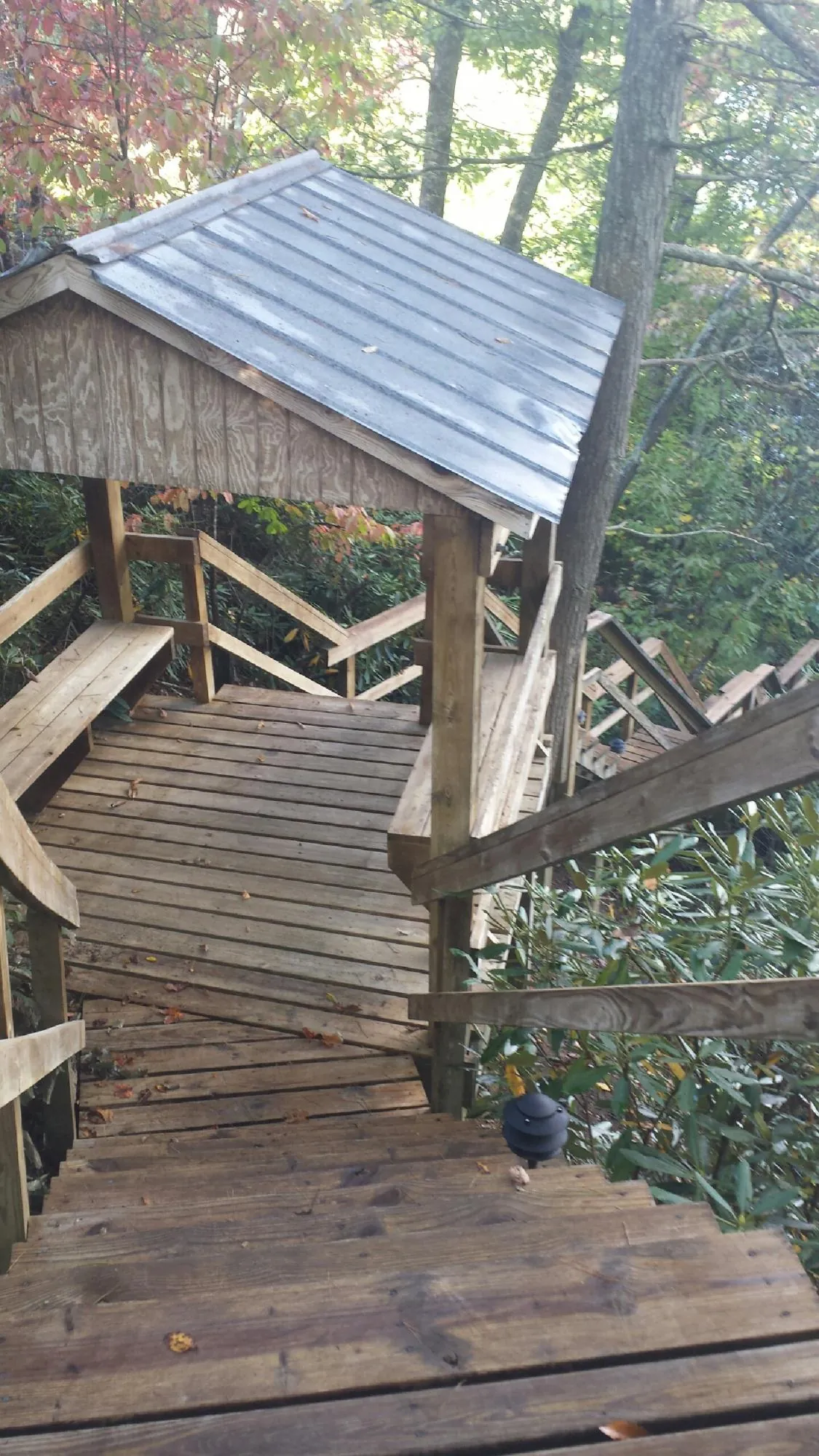Metal roofed shelter over wooden steps on a wooded walkway — Skylight Repair & Installation work by our crew in Amston