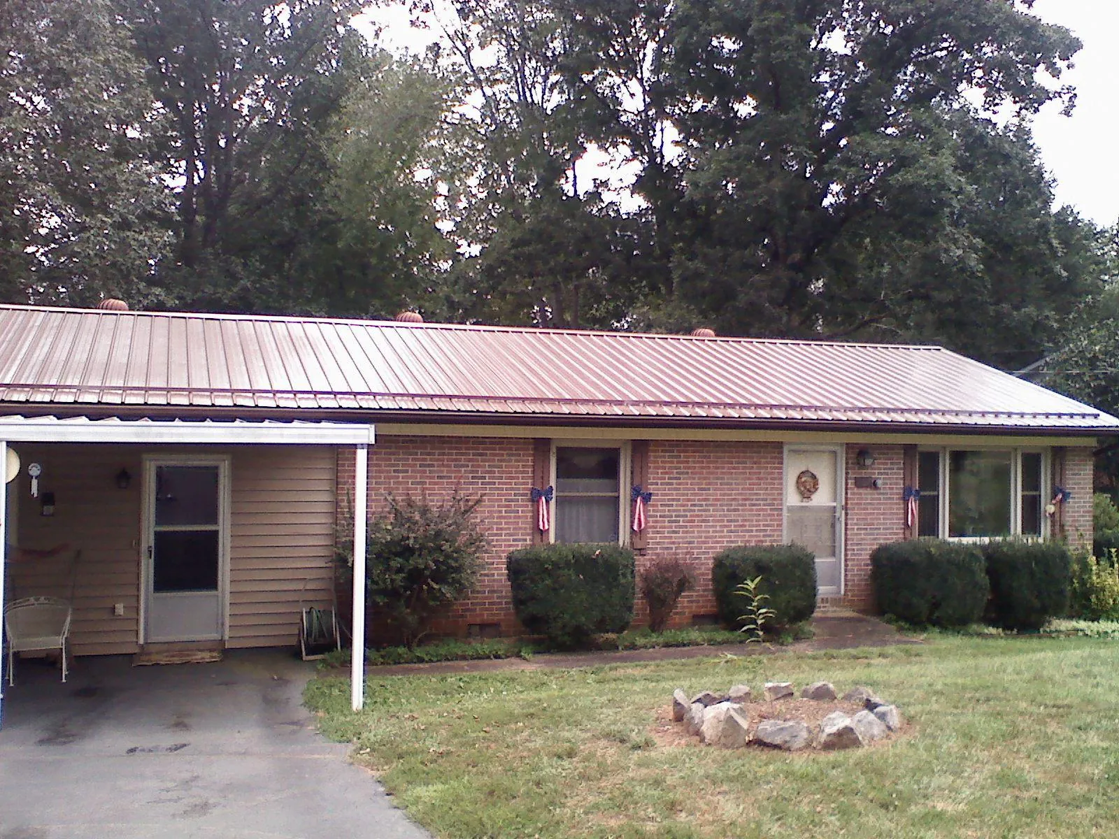 Bronze metal roof and carport on a brick ranch home — Roof Repair work by our crew in Amston